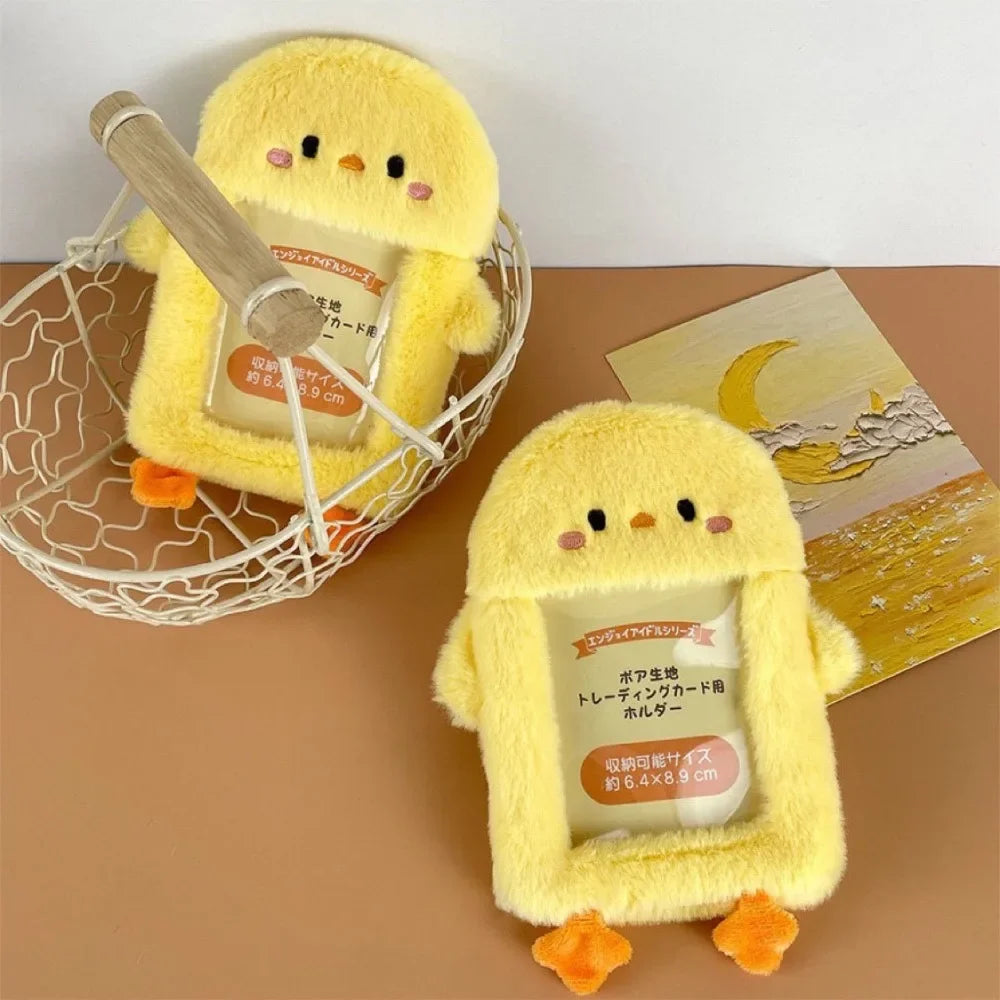 A yellow plush bird holding a card inside, displayed in a white wire basket.
