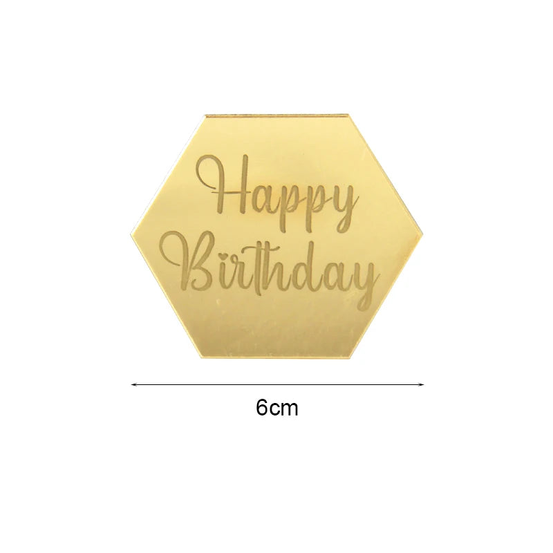 A gold hexagonal acrylic birthday topper with the words Happy Birthday engraved on it.