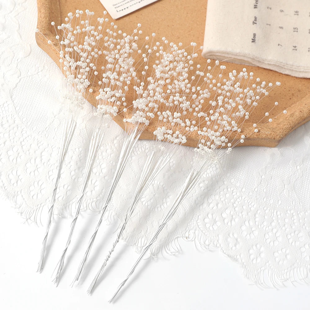 A bundle of pearl string beads is displayed on a kraft paper background next to white lace fabric.