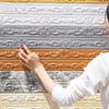 A hand is touching a decorative self-adhesive PVC corner trim featuring various textured and embossed patterns in silver, ora