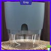 A gray self-watering transparent flower pot with a cotton rope visible at the bottom.