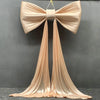 A large satin bow with long tulle drapes used for event decoration.