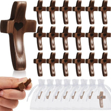 A set of small wooden cross charms for stress relief and meditation, shown next to a hand.