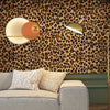 A modern living room featuring a leopard print wallpaper, a gold floor lamp, and a light-colored sofa.