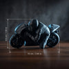 A black 3D printed figurine of a racing motorcycle rider in a low, aggressive stance.