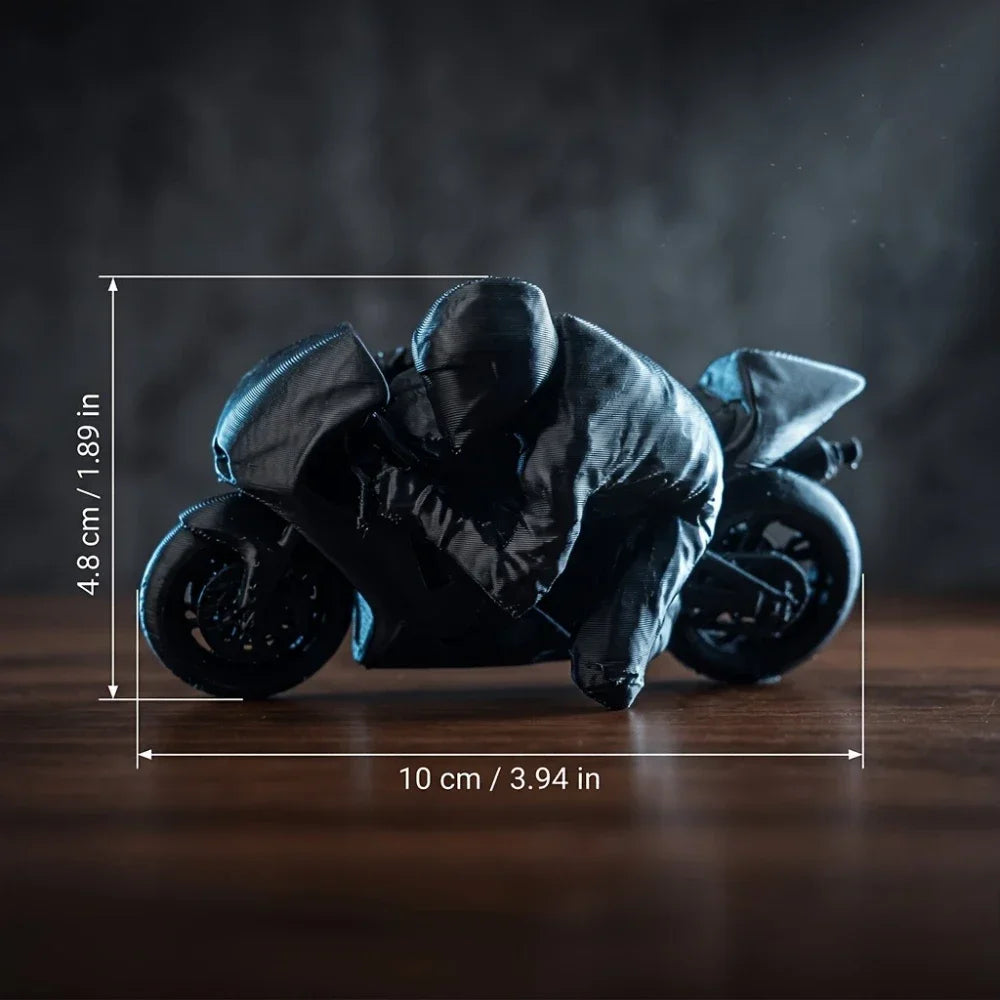 A black 3D printed figurine of a racing motorcycle rider in a low, aggressive stance.