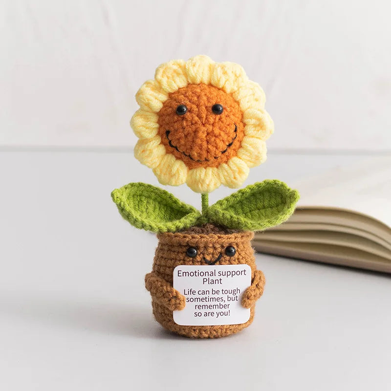 Handmade crochet sunflower desk companion with a smiling face and green leaves