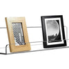 A clear acrylic floating storage rack set displaying two framed photos, one wooden and one black.