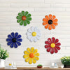 Iron sunflower wall art decor featuring various colored metal flowers mounted on a white brick wall.