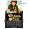 A hand-cranked wooden music box featuring characters from Once Upon a December on the lid and an open mechanism below.