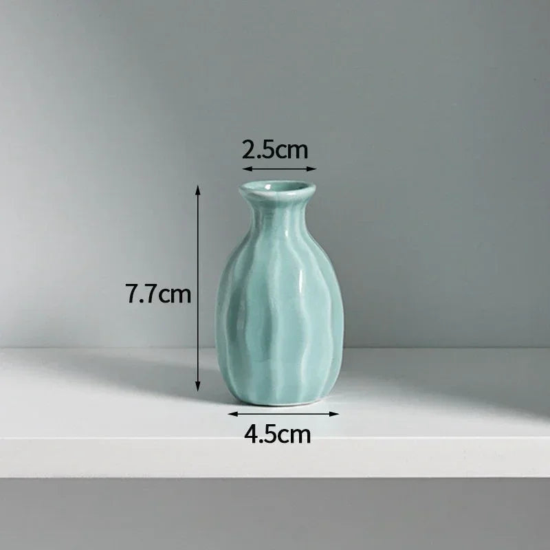 A light blue ceramic mini vase with a rounded body and narrow neck, shown against a white background.