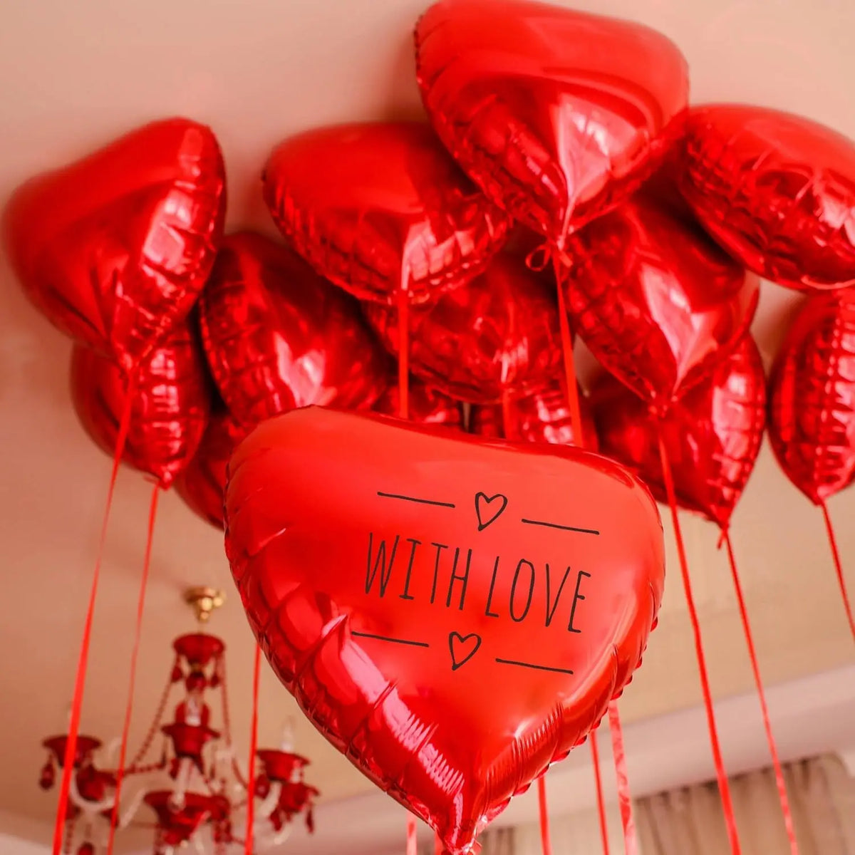 A cluster of shiny red heart foil balloons tied together, suitable for Valentine's Day or wedding decorations.