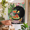 A tapestry featuring a black cat sitting on a glass filled with goldfish, set against a floral background.