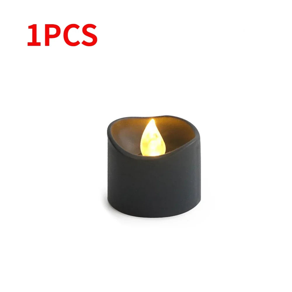 A single black LED candle with a warm white glow, shown in a close-up view.
