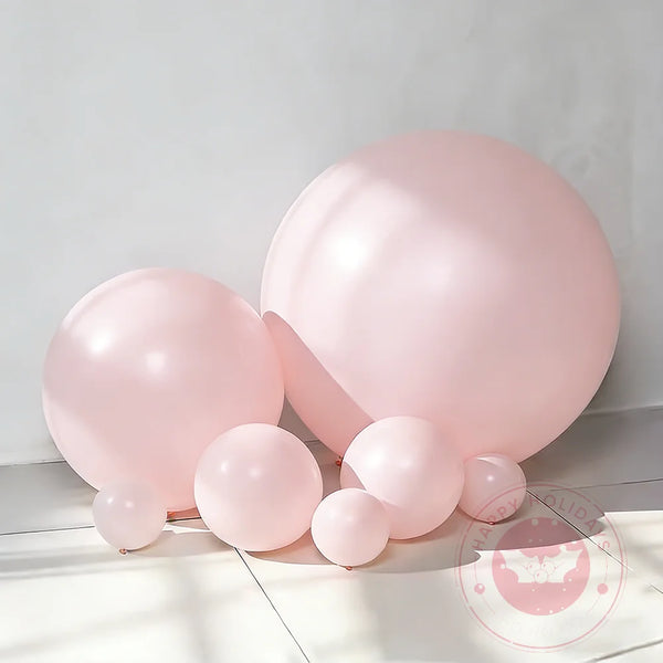 A cluster of pink latex balloons used for party decor, shown against a light background.