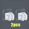Two white wall mounted holders for storing mops and brooms.