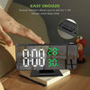 A hand is interacting with an LED digital projection alarm clock displaying 8:00 and a Snooze function feature.