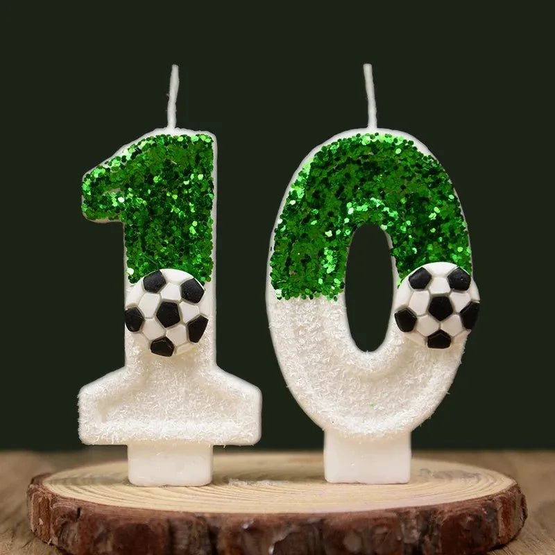Two white candles shaped like the numbers 1 and 0 decorated with green glitter resembling soccer balls
