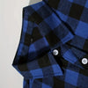 A close-up of a men's blue and black plaid flannel shirt with a collar and button placket.