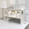 A white two-layer desktop organizer shelf featuring a lamp, stationery, and small appliances.