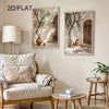 A living room scene featuring a light-colored sofa, a lamp, and two framed botanical canvas paintings of olive trees.