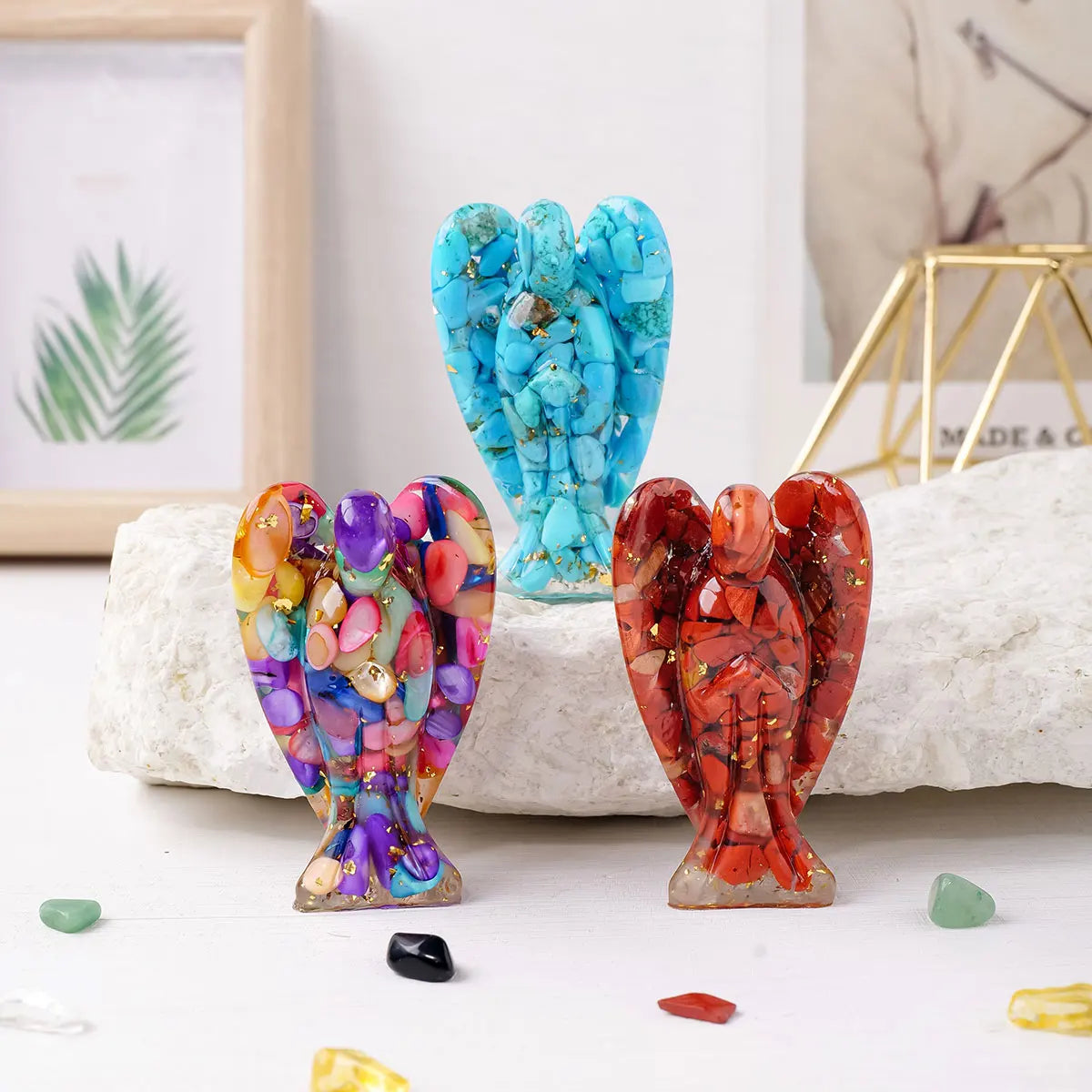 A collection of natural crystal guardian angel figurines in various shades of blue, purple, and red resting on a white surfac