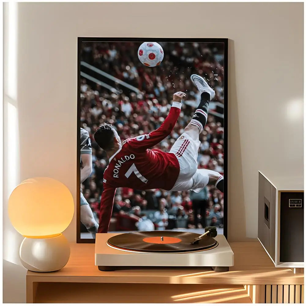 A framed poster of Cristiano Ronaldo in a dynamic pose against a blurred stadium background.
