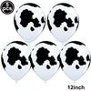 Five white foil balloons featuring a black cow print design for farm-themed parties