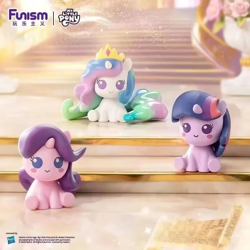 A collection of My Little Pony figurines, including a unicorn with a crown and other pony characters, displayed on a wooden s