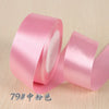 A roll of pink silk satin ribbon used for gift wrapping and craft projects.