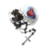 A set of wooden beads and a crucifix necklace displayed in a glass container with an image of Jesus.