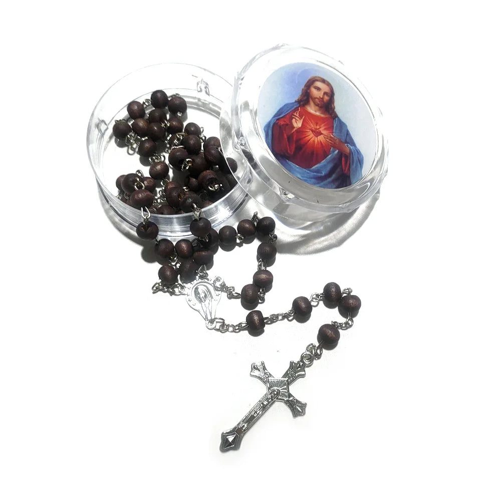 A set of wooden beads and a crucifix necklace displayed in a glass container with an image of Jesus.