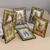 A collection of framed Catholic icons featuring Jesus, Mary, and the Archangel St. Michael on a light-colored surface.