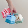 A hand is holding a pink plastic dog basket toy set with various colored baskets.