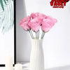 A bouquet of pink artificial roses in a white vase displayed on a white surface.