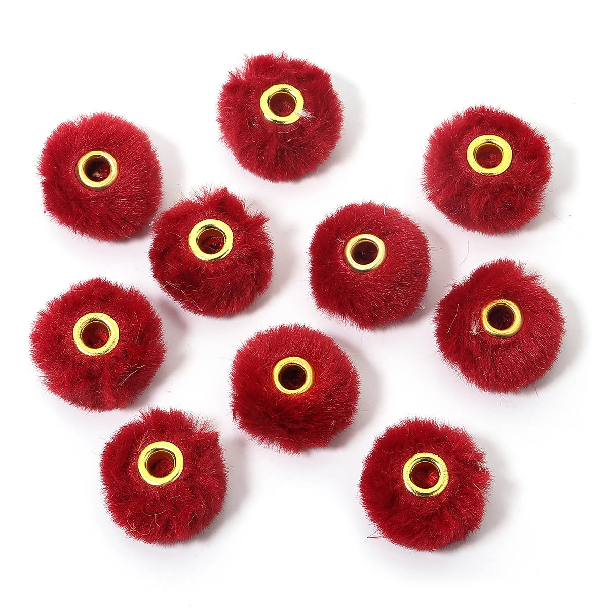 Collection de boules de fourrure rouge vif utilisées comme perles pour la fabrication de bijoux DIY.