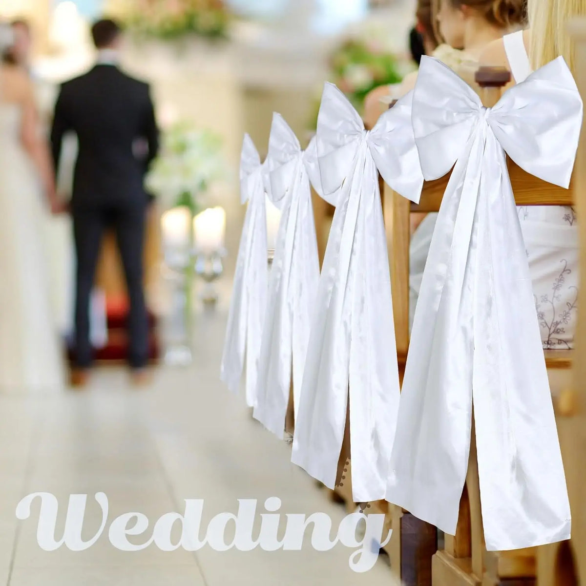 Présentation de grands nœuds de mariage en satin blanc accrochés sur un porte-servi à bois dans un intérieur lumineux.