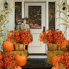 Un bouquet de fleurs d'automne et d'Halloween artificiel avec des feuillages orange et rouge et des citrouilles.