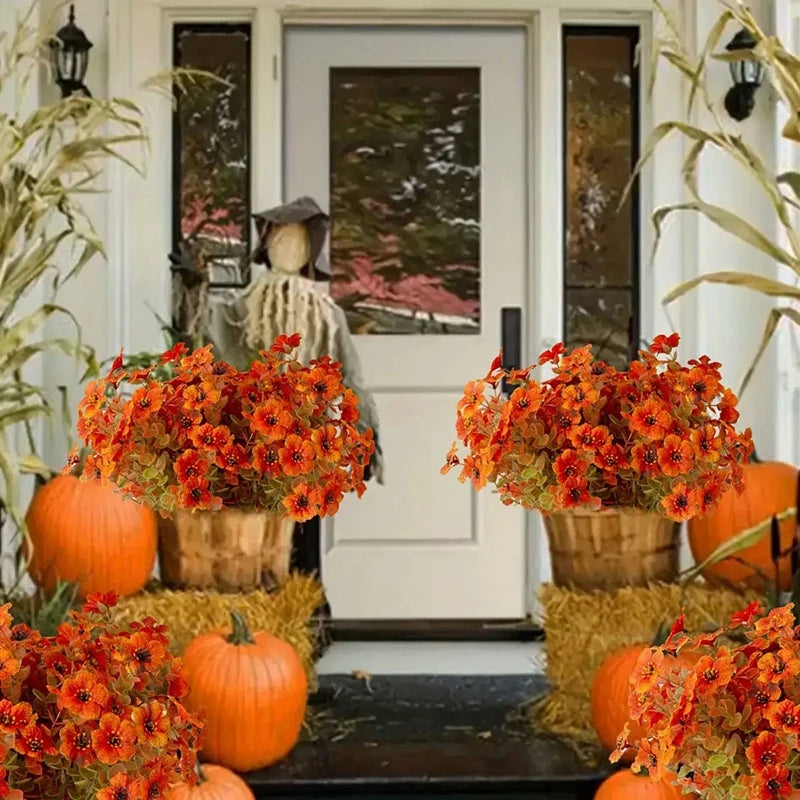 Un bouquet de fleurs d'automne et d'Halloween artificiel avec des feuillages orange et rouge et des citrouilles.