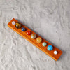A wooden bar displaying a set of natural crystal solar system planet balls in various colors.
