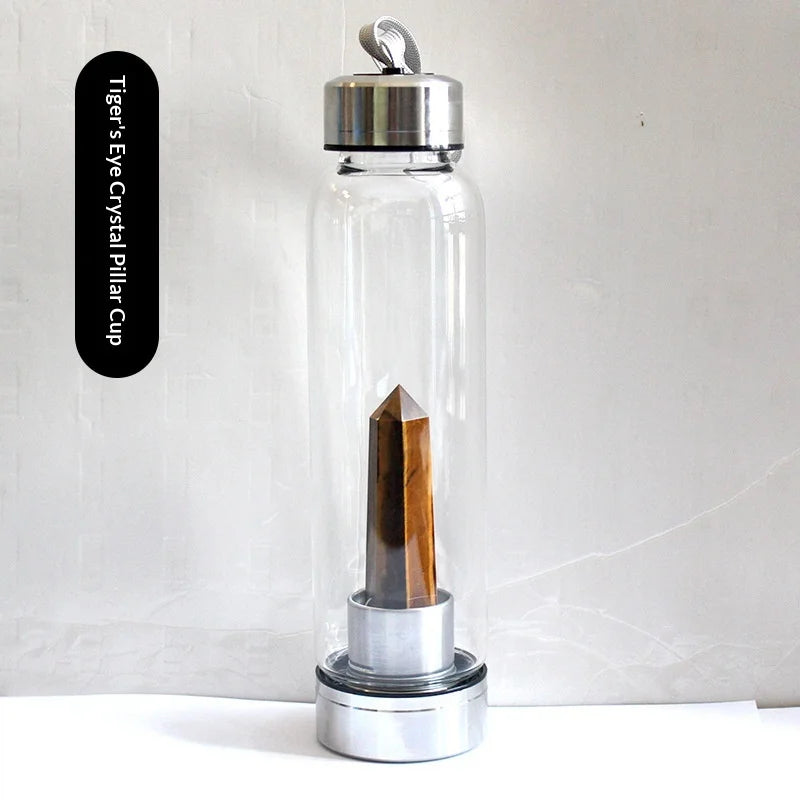 Botella de agua de vidrio transparente con tapa plateada y un pilar de cristal de madera dentro.