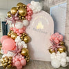 A balloon garland arch kit featuring pastel pink and white balloons arranged in a decorative display.