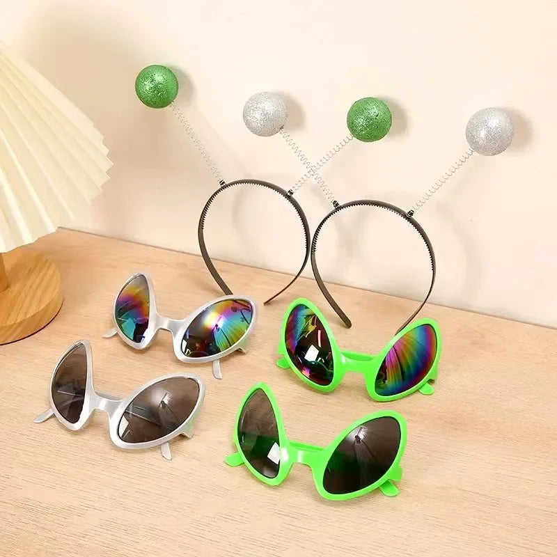 A collection of rainbow alien sunglasses in various colors and styles displayed on a wooden surface.