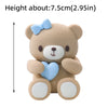 A light brown teddy bear block topper with a blue bow and heart design.