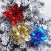 Red, gold, and blue silk artificial Christmas flowers with sparkle finish on a snowy green branch