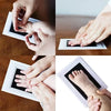 Hands print on a white pad showing baby hand and foot impressions.