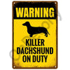 A vintage metal sign with a yellow background and black text warning about a killer Dachshund on duty.