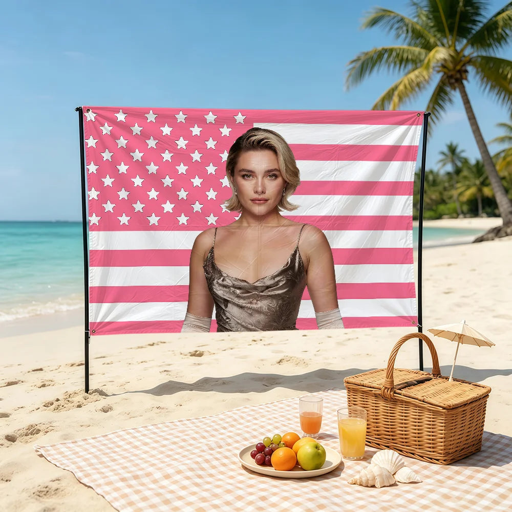 A decorative flag banner featuring pink and white stripes with stars, set up on a beach with a woman in front.
