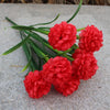 Un bouquet de fleurs d'hydrangea artificielles rouge vif posé sur une surface de pierre grise.