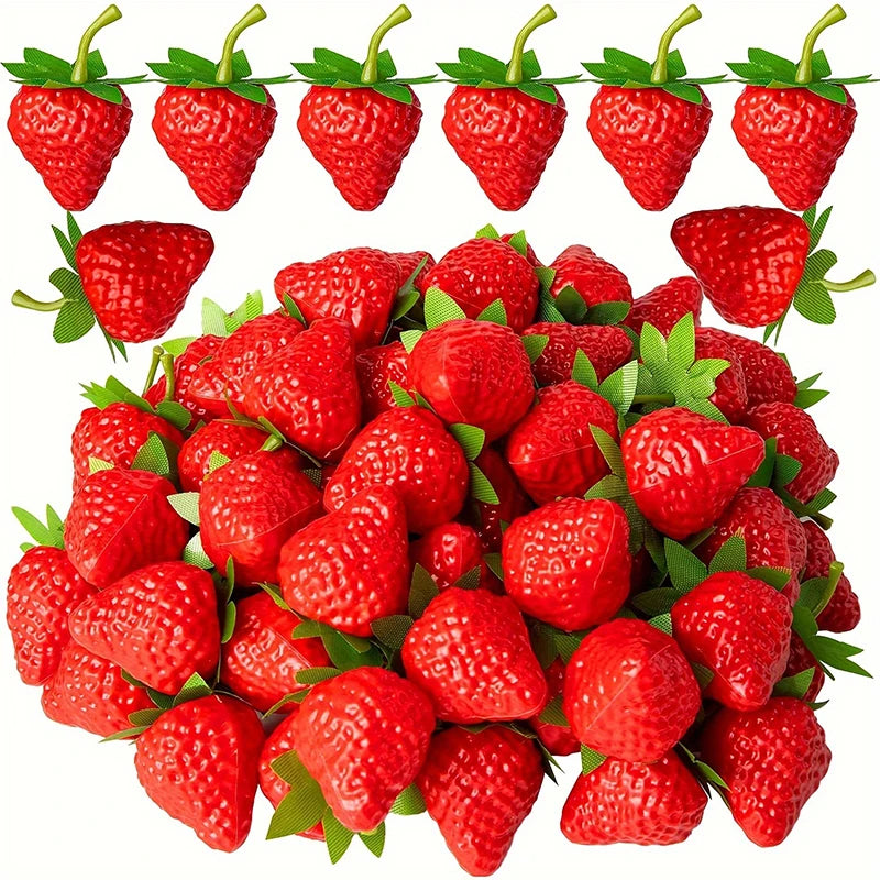 A cluster of bright red artificial strawberries on green leaves.